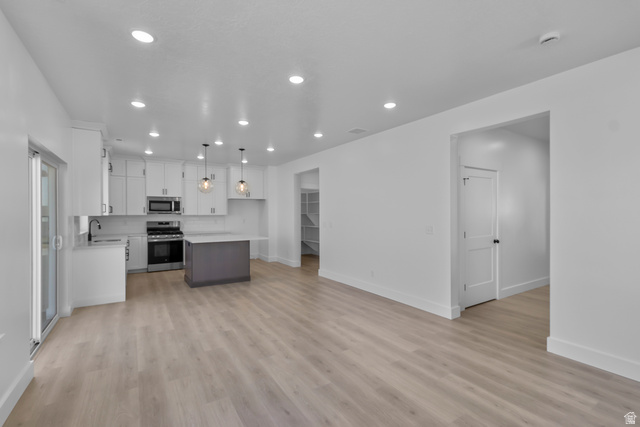 1213 West 500 South Logan, UT 84321 - Photo 6 of 29 Modern kitchen featuring light-finish cabinetry, stainless steel appliances, a dark gray island, and pendant lighting