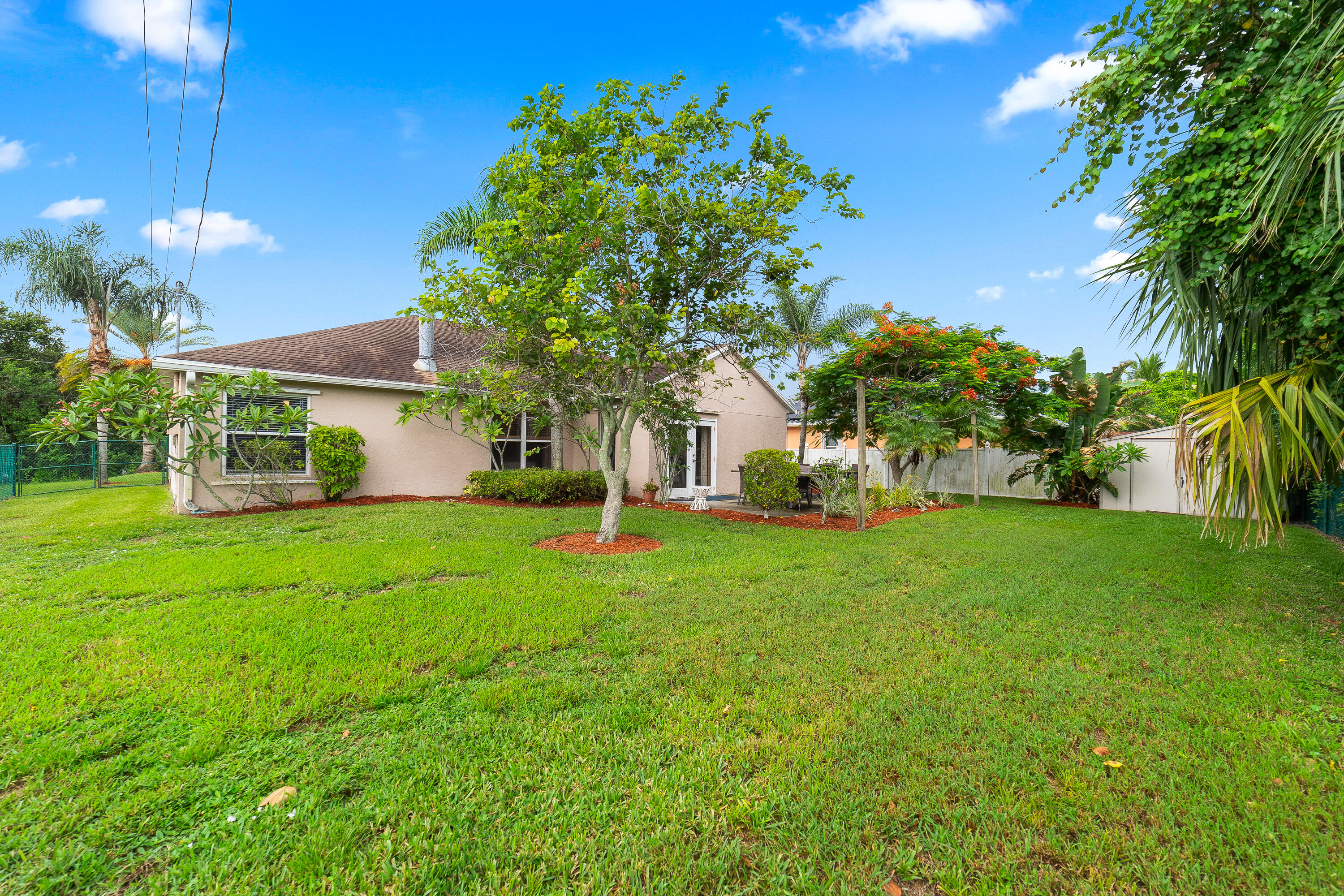 4292 Southwest Whitebread Road Port St. Lucie, FL 34953 - Photo 23 of 28 a front view of a house with garden
