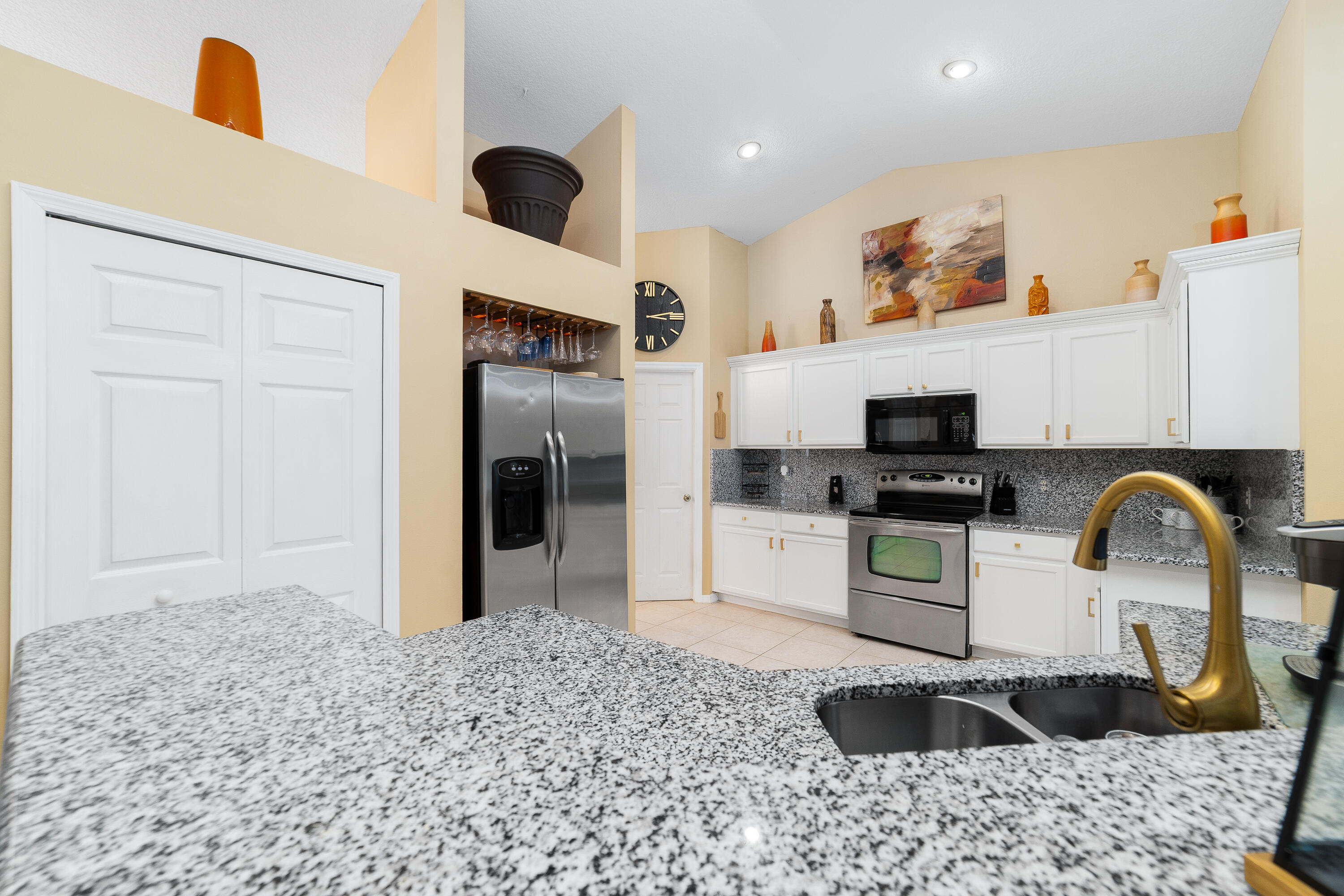 4292 Southwest Whitebread Road Port St. Lucie, FL 34953 - Photo 4 of 28 a kitchen with stainless steel appliances kitchen island granite countertop a refrigerator and a stove top oven