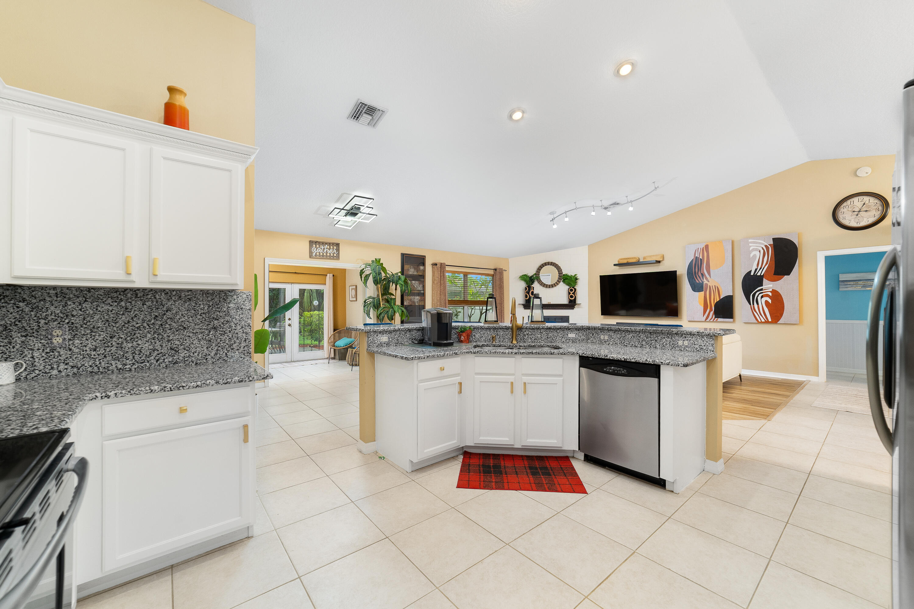 4292 Southwest Whitebread Road Port St. Lucie, FL 34953 - Photo 6 of 28 a kitchen with stainless steel appliances granite countertop a sink and dishwasher a stove top oven with white cabinets