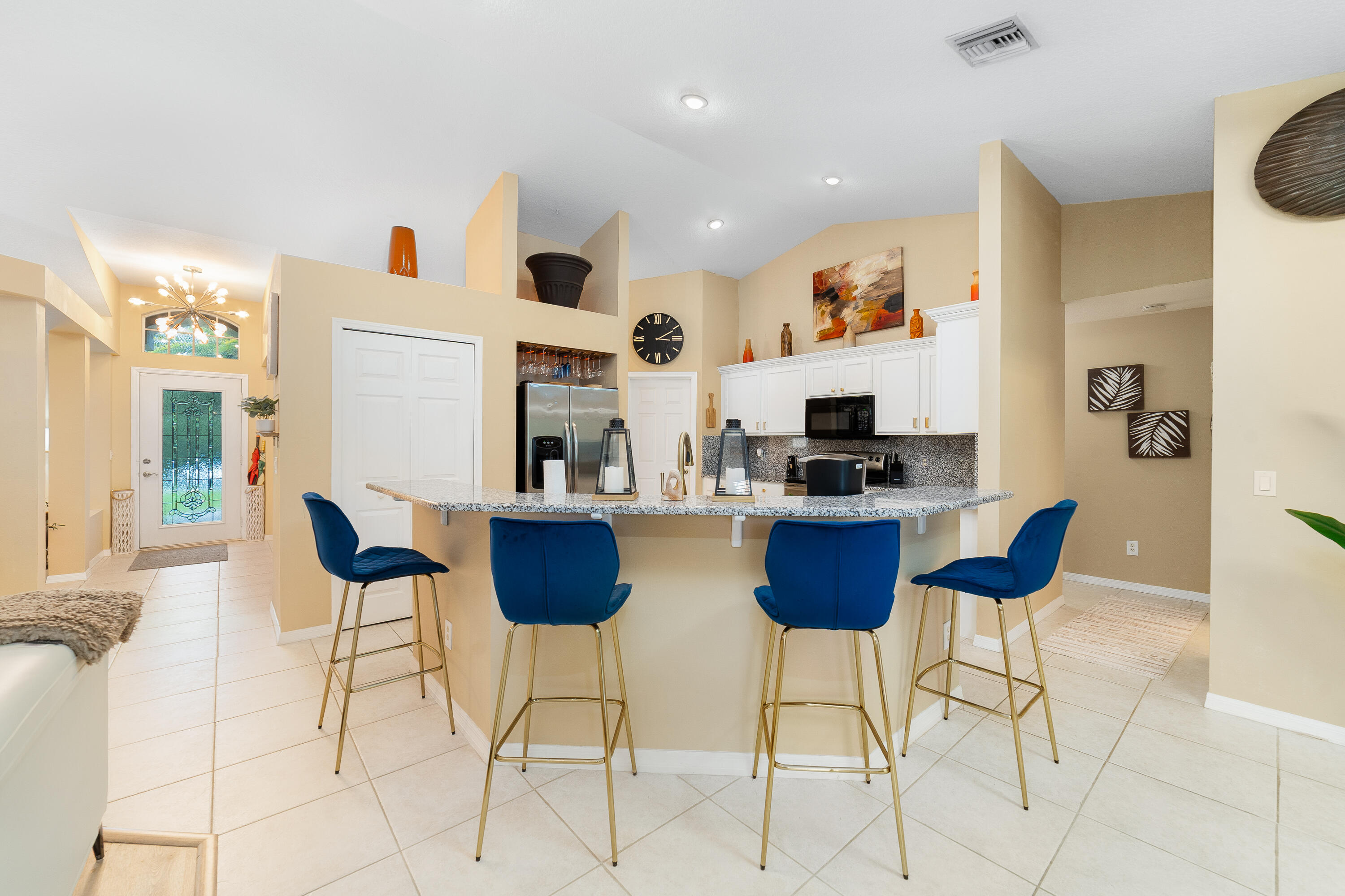 4292 Southwest Whitebread Road Port St. Lucie, FL 34953 - Photo 7 of 28 a view of kitchen with stainless steel appliances kitchen island granite countertop a refrigerator and chairs