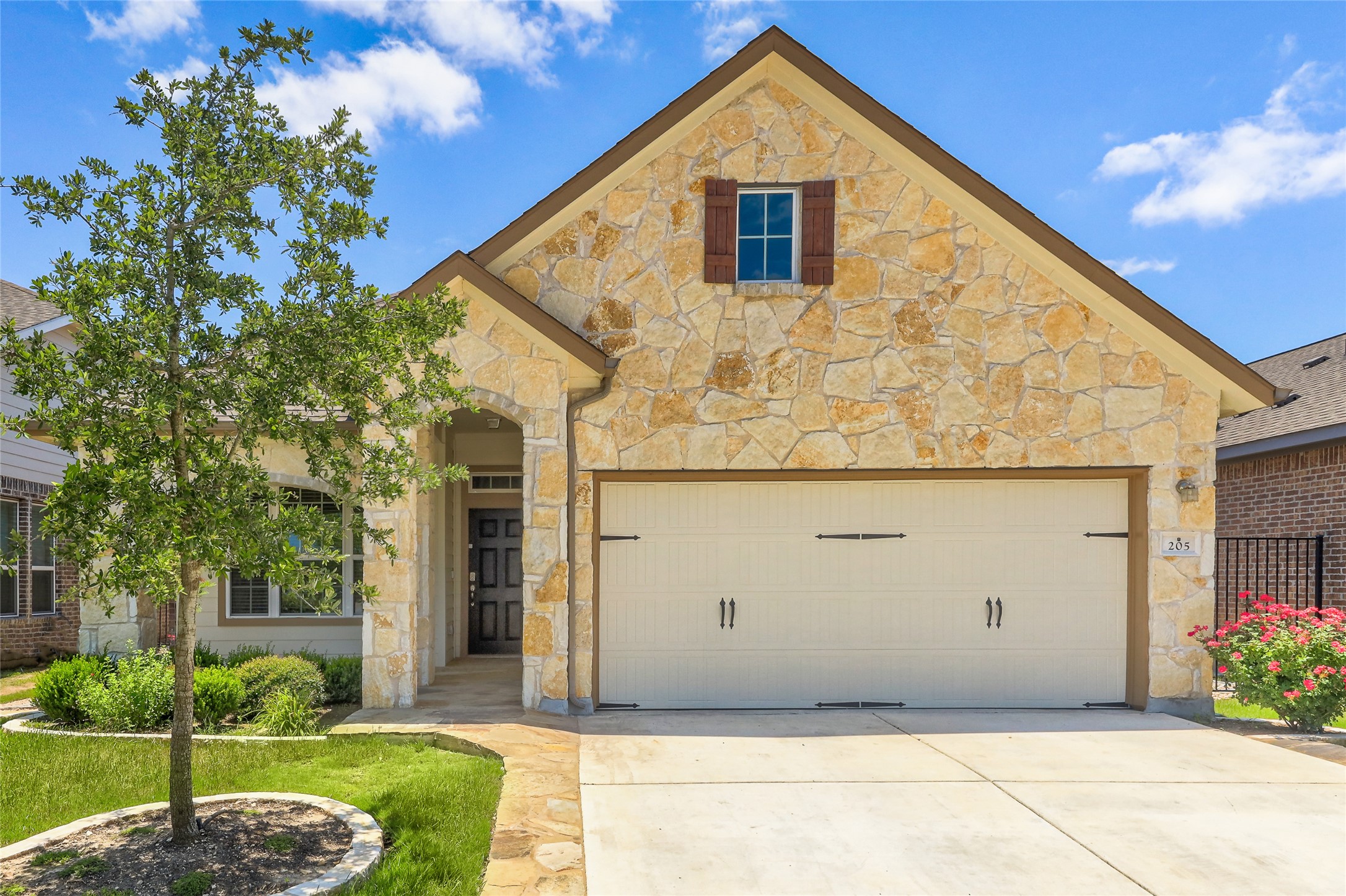 205 Penna Lane Georgetown, TX 78628 - Photo 32 of 32 A welcoming stone facade with an arched entry and integrated garage awaits.