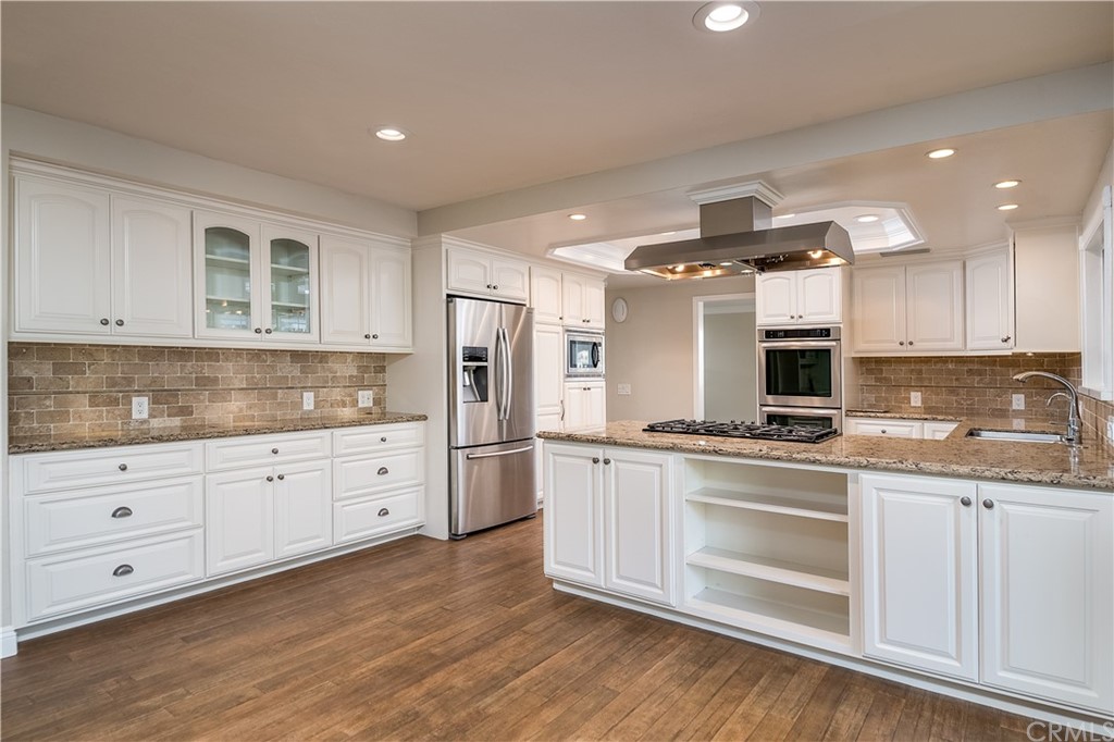 12513 Carinthia Drive Whittier, CA 90601 - Photo 11 of 35 a kitchen with stainless steel appliances granite countertop a stove and white cabinets