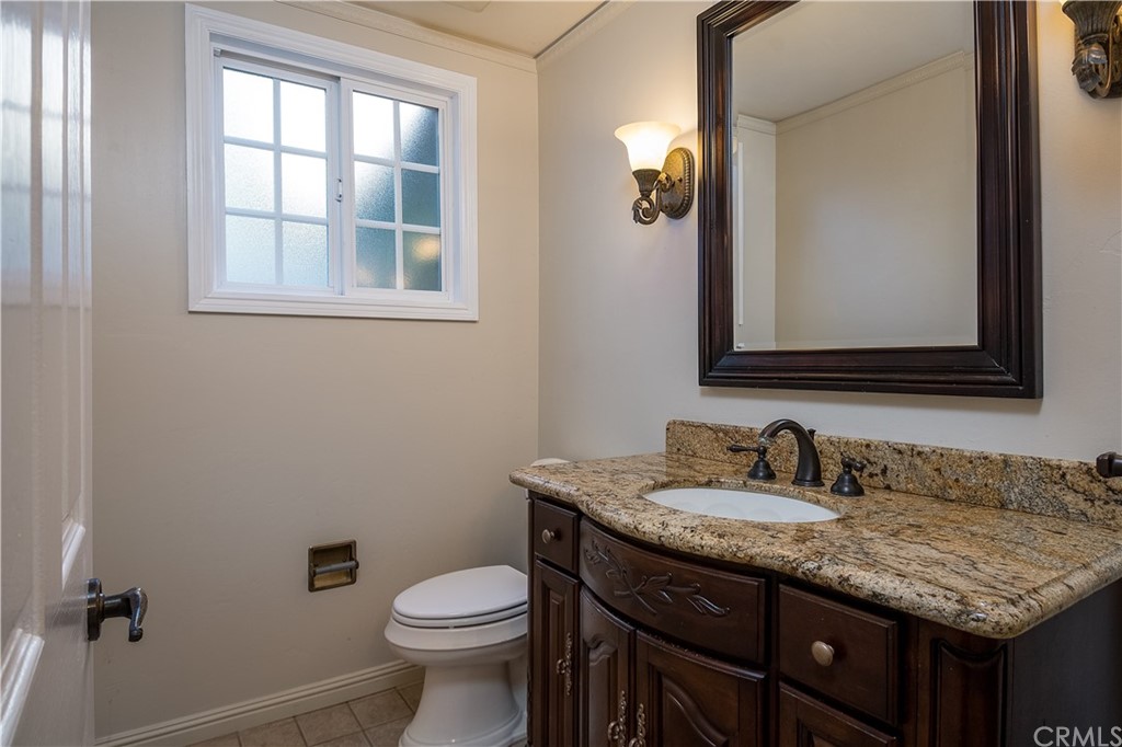 12513 Carinthia Drive Whittier, CA 90601 - Photo 15 of 35 a bathroom with a granite countertop toilet sink and mirror