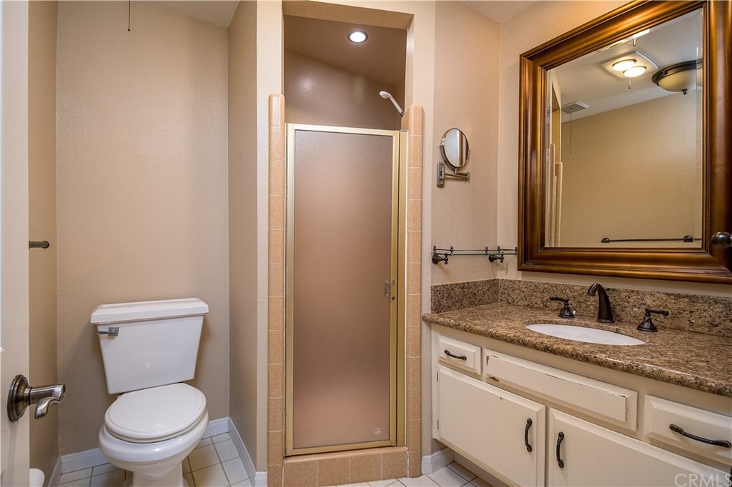 12513 Carinthia Drive Whittier, CA 90601 - Photo 19 of 35 a bathroom with a granite countertop toilet sink and mirror