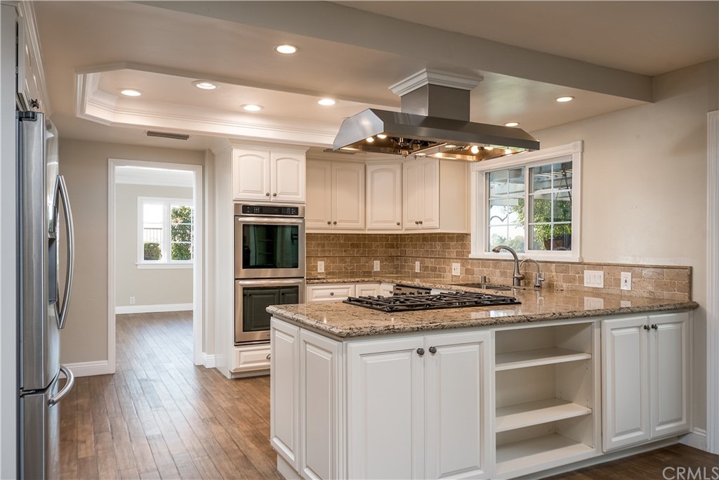 12513 Carinthia Drive Whittier, CA 90601 - Photo 10 of 35 a kitchen with kitchen island granite countertop a sink cabinets and stainless steel appliances