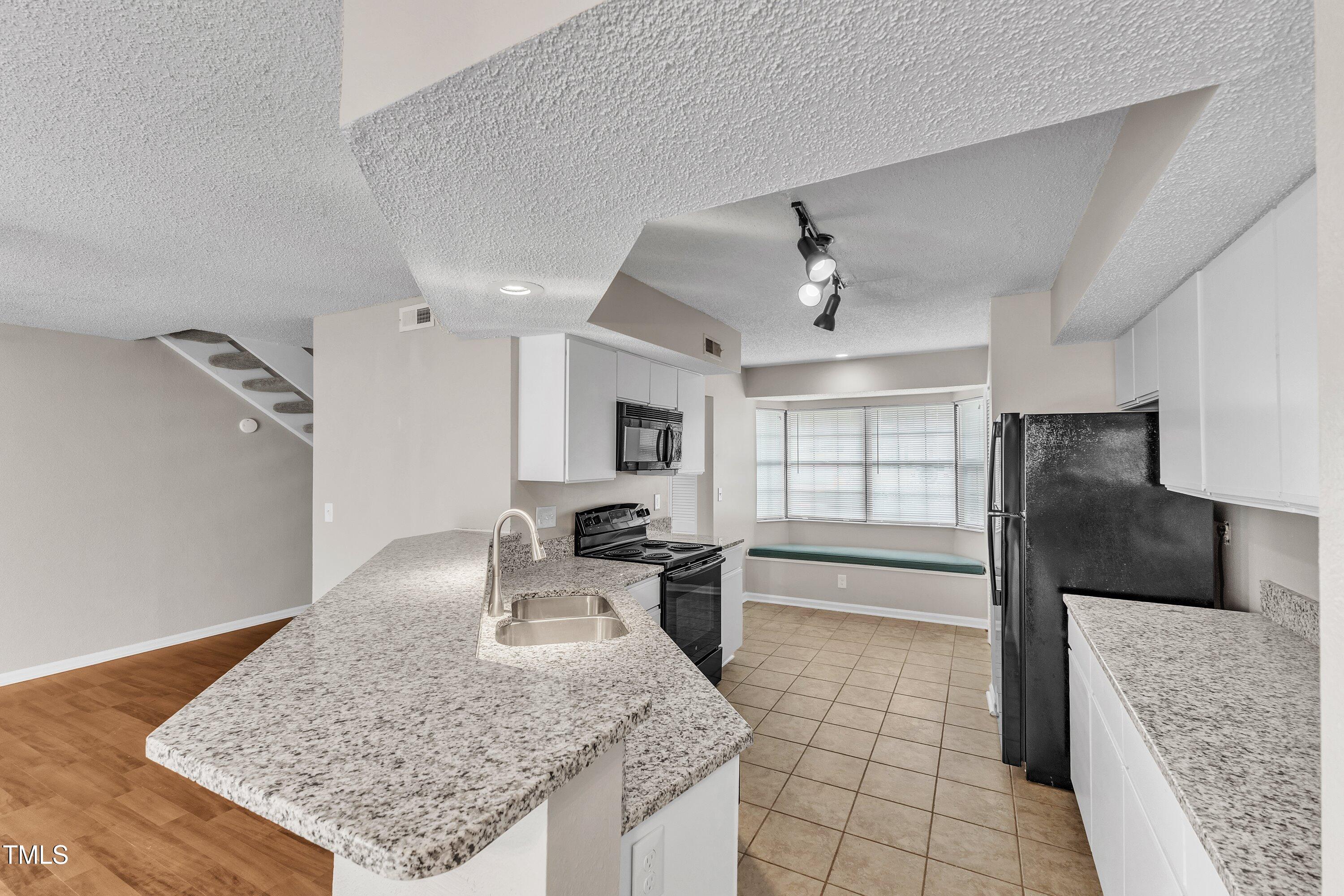 7811 Falcon Rest Circle Raleigh, NC 27615 - Photo 15 of 39 a view of a kitchen with kitchen island a counter top space appliances a sink and cabinets