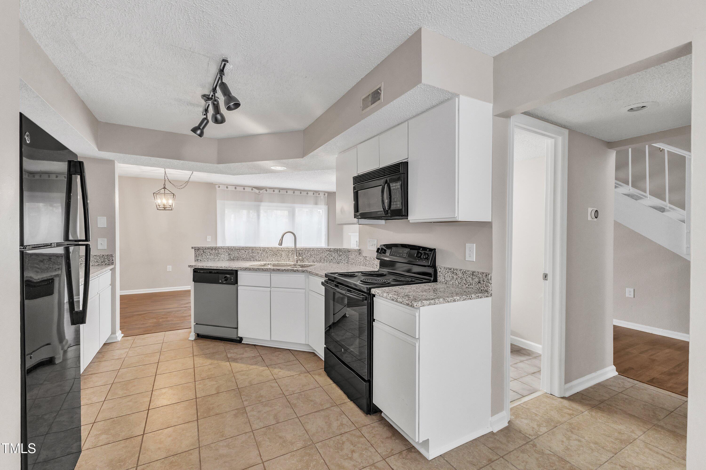 7811 Falcon Rest Circle Raleigh, NC 27615 - Photo 16 of 39 a kitchen with stainless steel appliances granite countertop a refrigerator stove top oven and sink