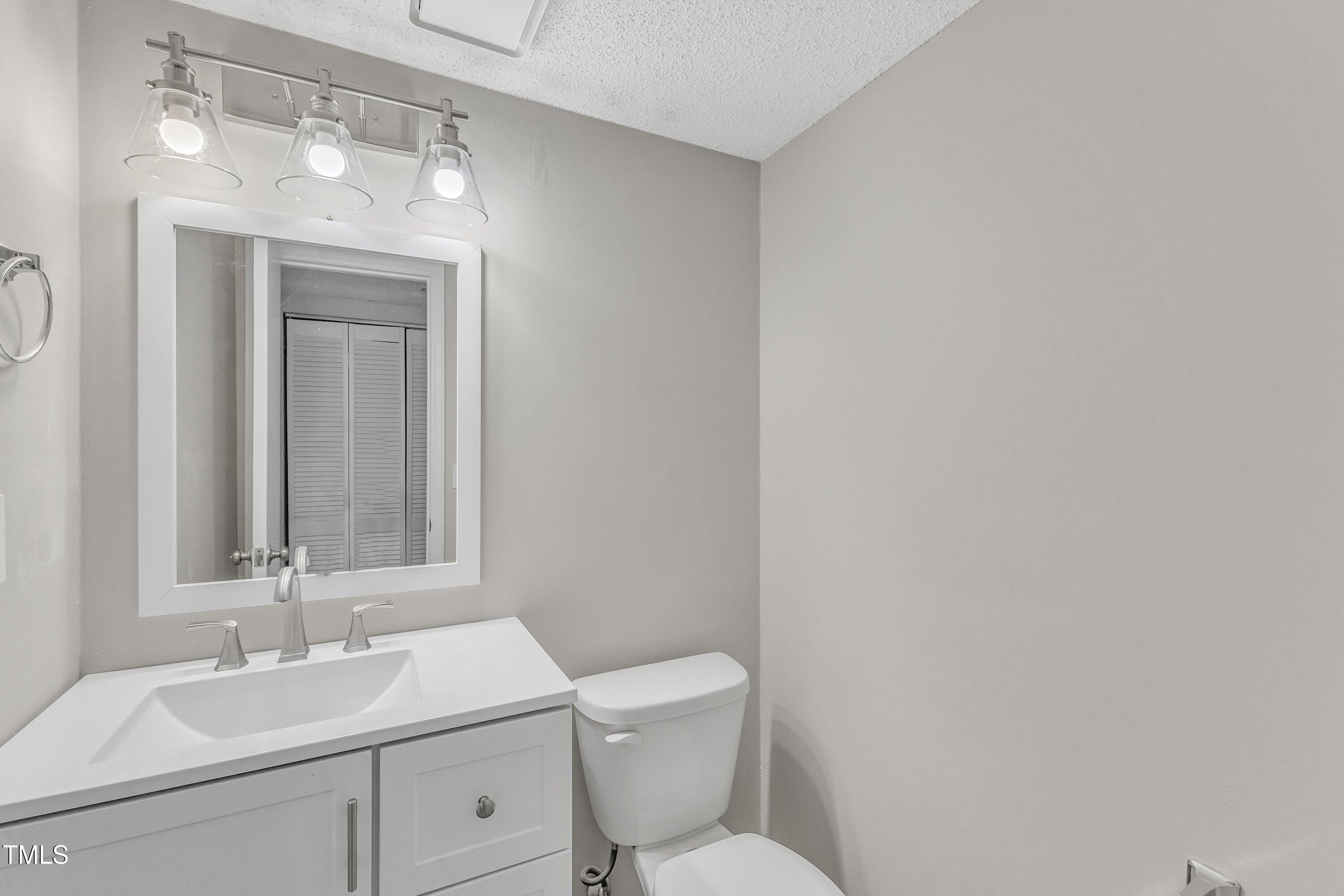 7811 Falcon Rest Circle Raleigh, NC 27615 - Photo 21 of 39 a bathroom with a toilet sink and mirror
