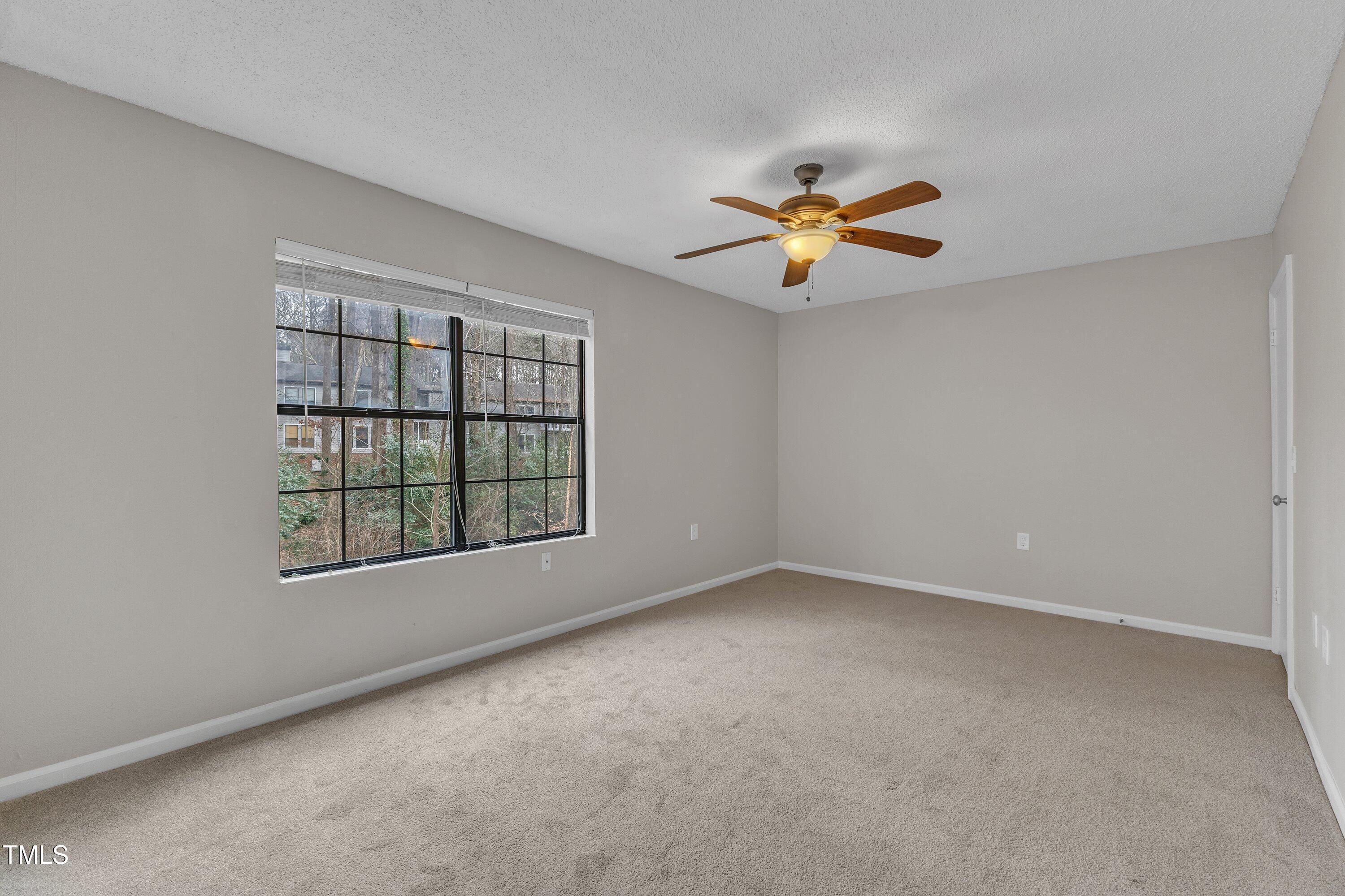 7811 Falcon Rest Circle Raleigh, NC 27615 - Photo 29 of 39 an empty room with a window and a ceiling fan