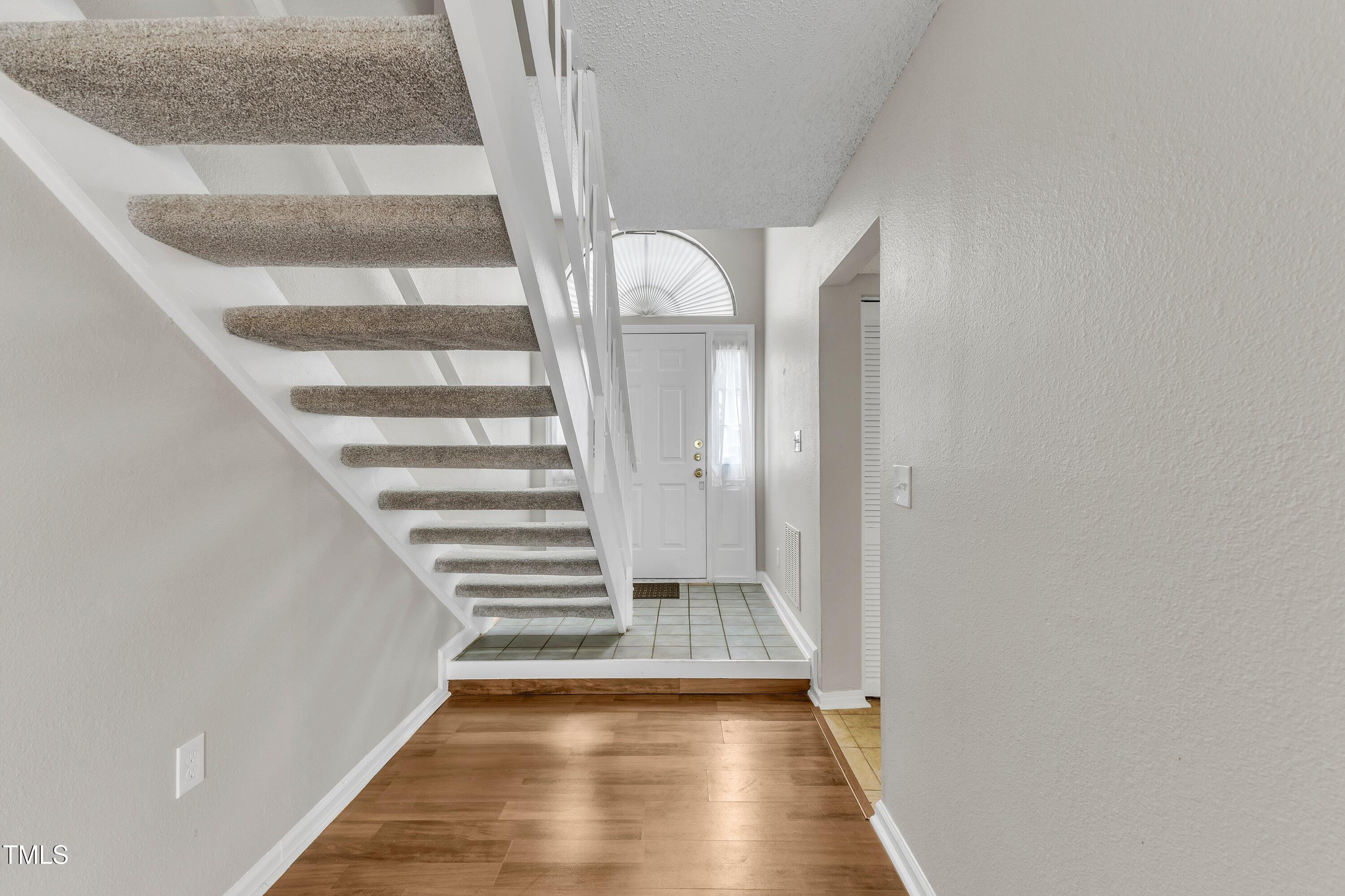 7811 Falcon Rest Circle Raleigh, NC 27615 - Photo 5 of 39 a view of staircase with wooden floor and white walls