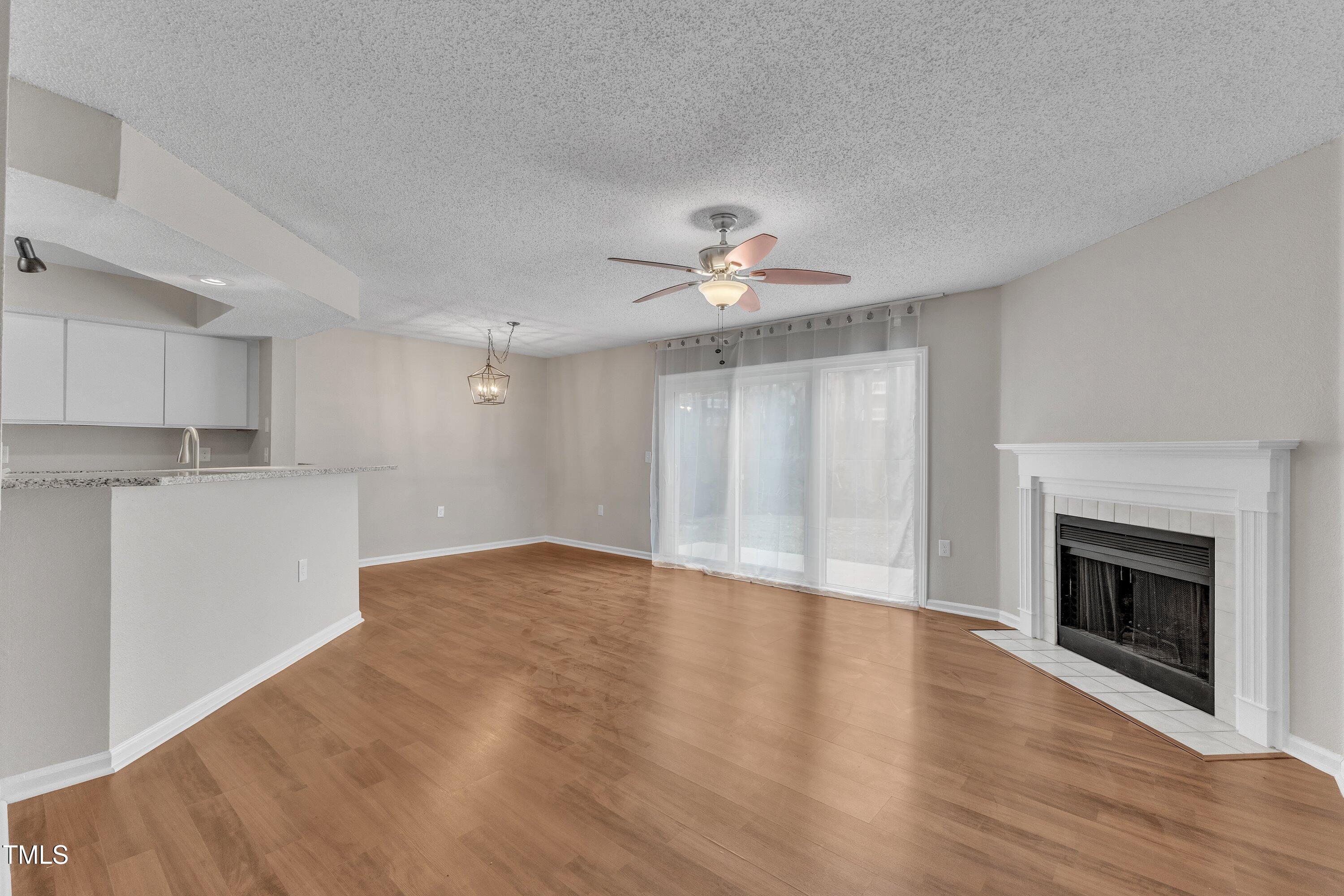 7811 Falcon Rest Circle Raleigh, NC 27615 - Photo 8 of 39 a view of an empty room with wooden floor and a fireplace