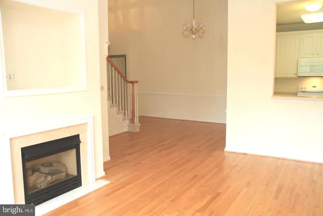 a view of a hallway with wooden floor and a fireplace