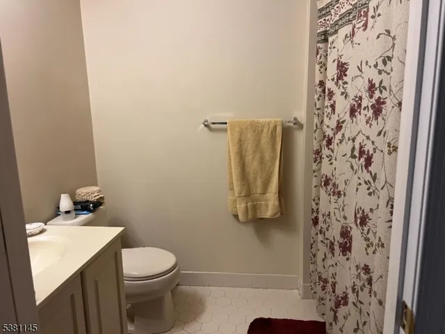 a bathroom with a toilet and shower curtain