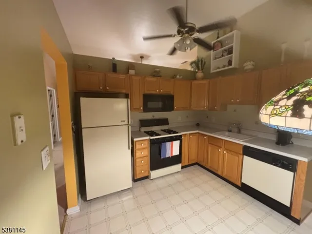 a kitchen with granite countertop a refrigerator and a sink