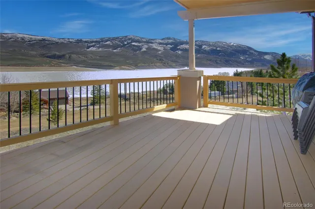 a view of a balcony with wooden floor and a floor to ceiling window