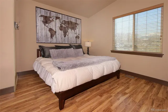 a large bed sitting in a bedroom next to a window