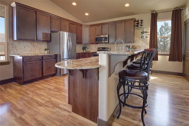 a kitchen with stainless steel appliances wooden floors and wooden cabinets