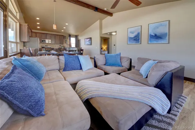 a living room with furniture and kitchen view