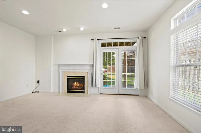 a view of an empty room with a fireplace and a window