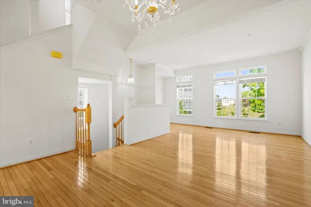 a view of empty room with wooden floor and window