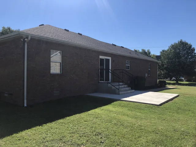a kitchen with stainless steel appliances granite countertop a refrigerator a sink and wooden floors