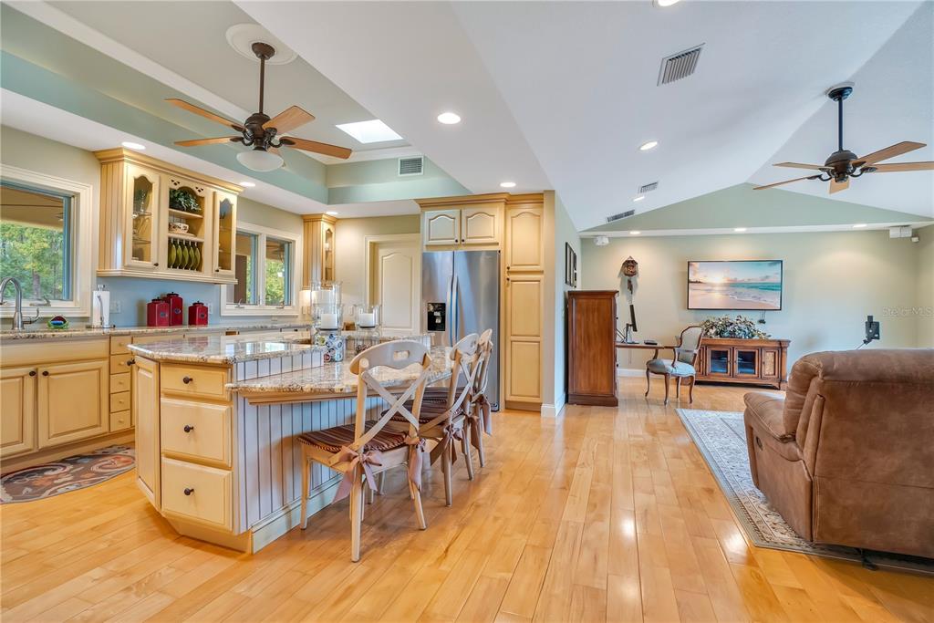 11450 Fangorn Road Orlando, FL 32825 - Photo 18 of 58 a kitchen with stainless steel appliances kitchen island granite countertop a table chairs and a refrigerator
