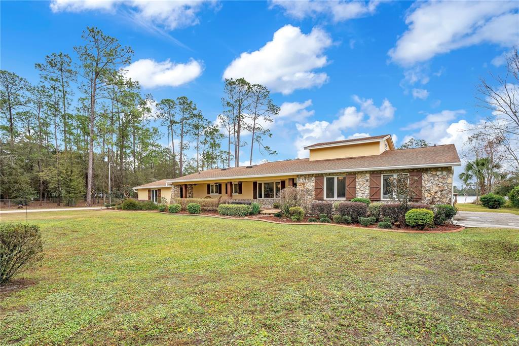 11450 Fangorn Road Orlando, FL 32825 - Photo 2 of 58 a view of a house with a big yard and large trees