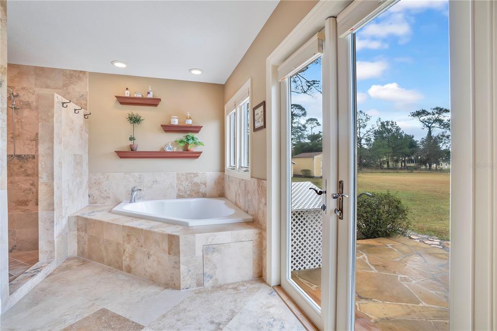 11450 Fangorn Road Orlando, FL 32825 - Photo 34 of 58 a bathroom with a granite countertop sink a mirror a bathtub and next to a window