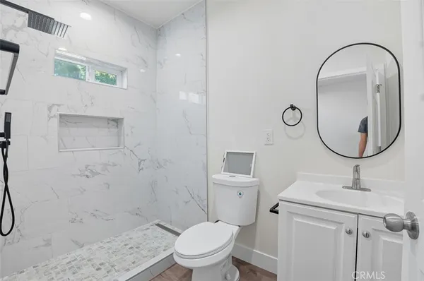 a bathroom with a sink a toilet and a mirror