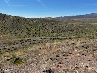 a view of a dry yard with mountains in the background