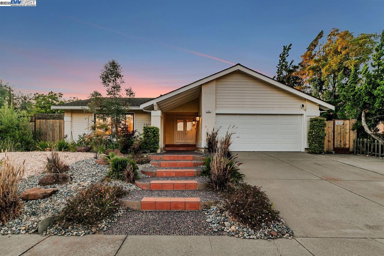 a front view of a house with a yard and potted plants