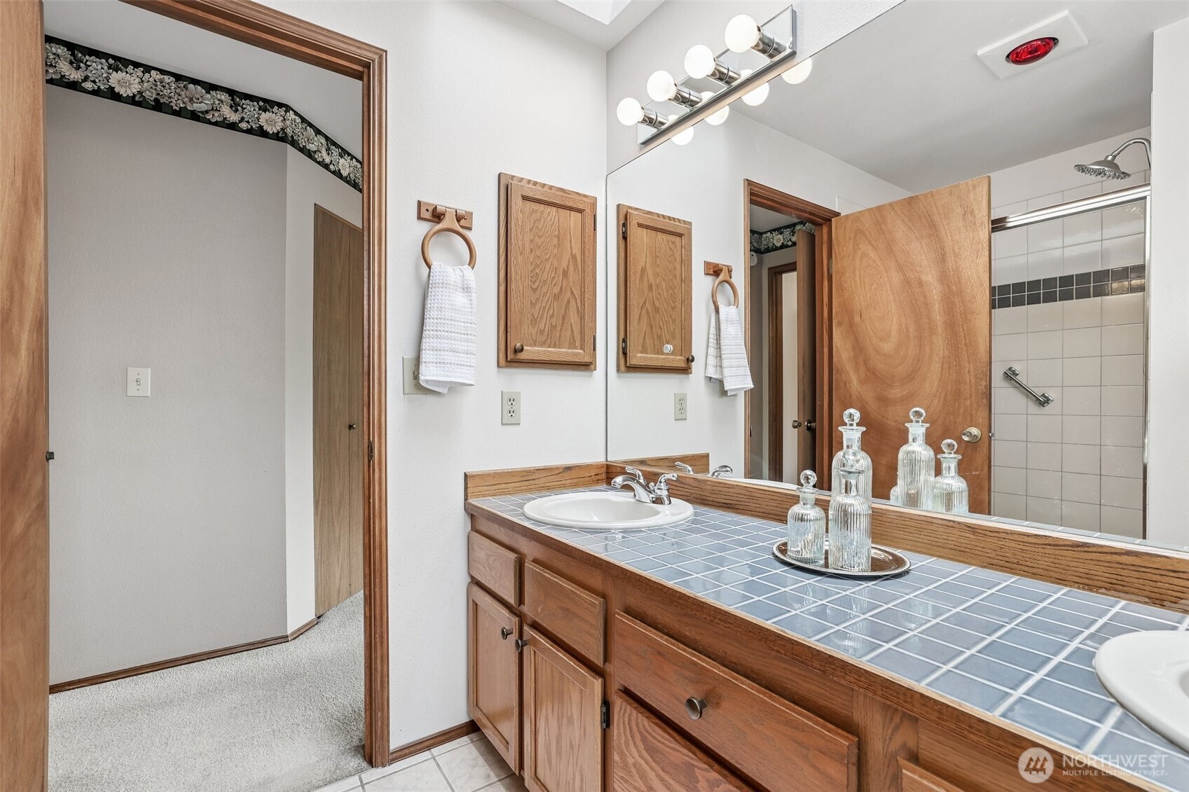15601 160th Court Southeast Renton, WA 98058 - Photo 15 of 19 a view of a bathroom with a granite countertop sink a mirror and shower view