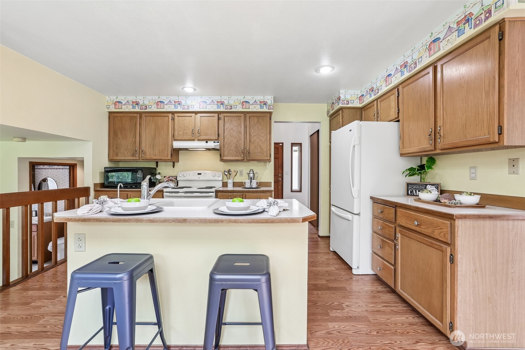 15601 160th Court Southeast Renton, WA 98058 - Photo 7 of 19 a kitchen with kitchen island a stove a refrigerator and wooden cabinets