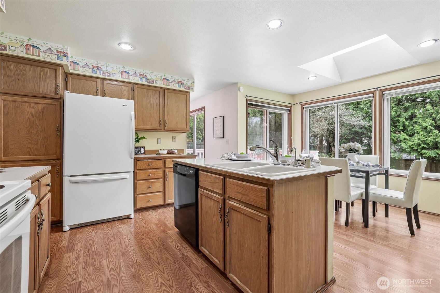 15601 160th Court Southeast Renton, WA 98058 - Photo 8 of 19 a kitchen with a refrigerator a stove top oven and a dining table