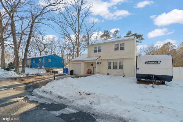 a view of a house with a yard covered in snow