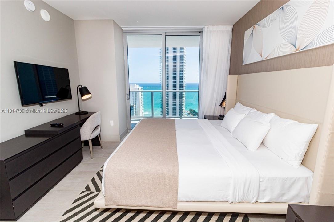 4010 South Ocean Drive, Unit R1905 Hollywood, FL 33019 - Photo 15 of 84 a bedroom with a bed and a flat screen tv