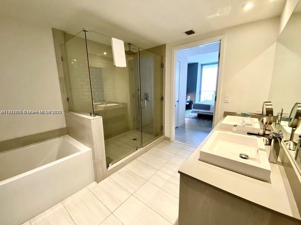 4010 South Ocean Drive, Unit R1905 Hollywood, FL 33019 - Photo 17 of 84 a bathroom with a tub sink shower and mirror