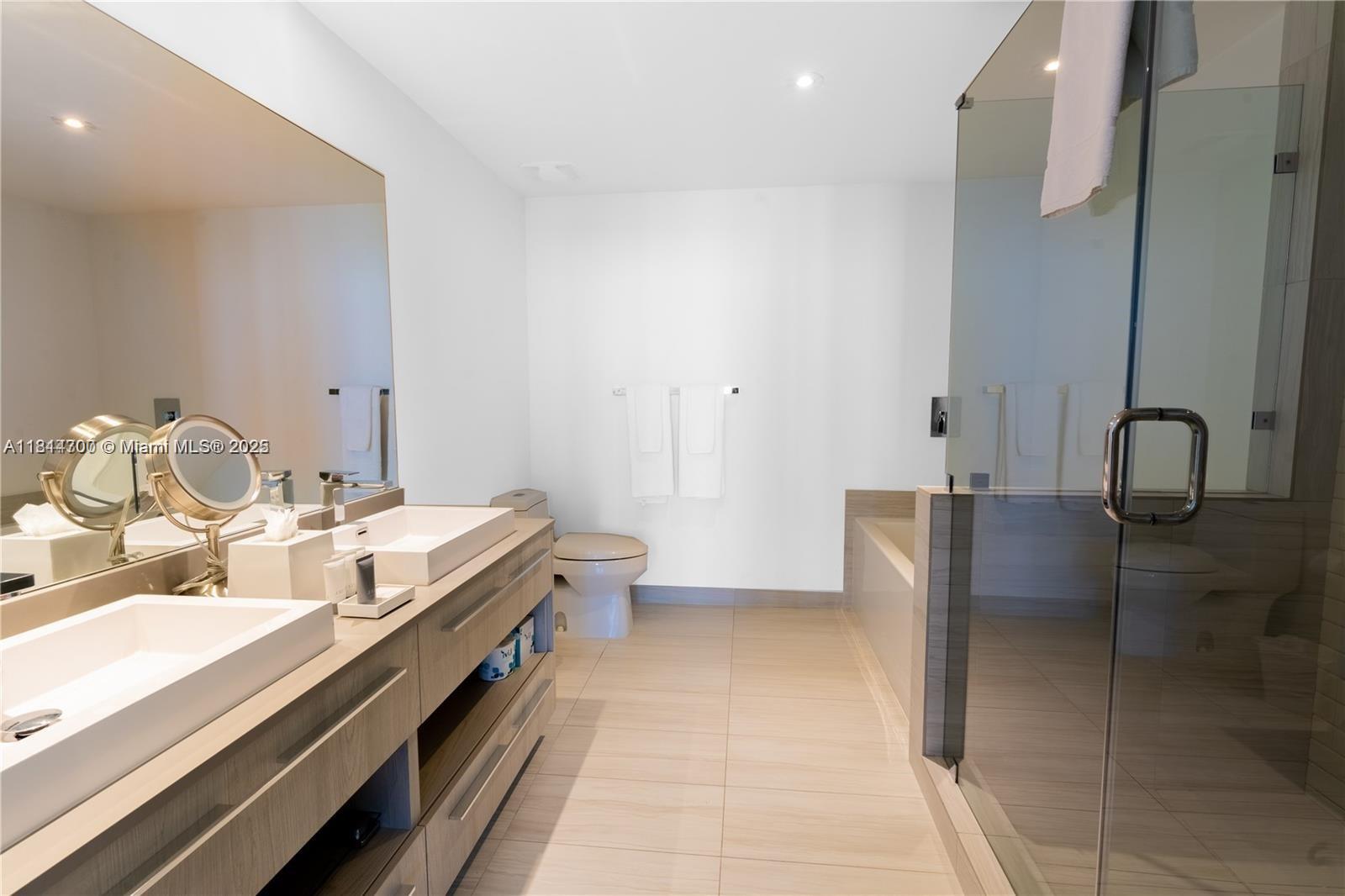 4010 South Ocean Drive, Unit R1905 Hollywood, FL 33019 - Photo 18 of 84 a spacious bathroom with a double vanity sink and a mirror