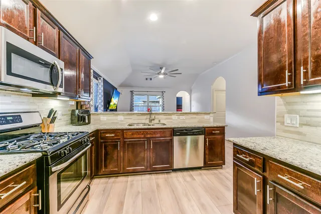 a kitchen with stainless steel appliances granite countertop a stove and a sink