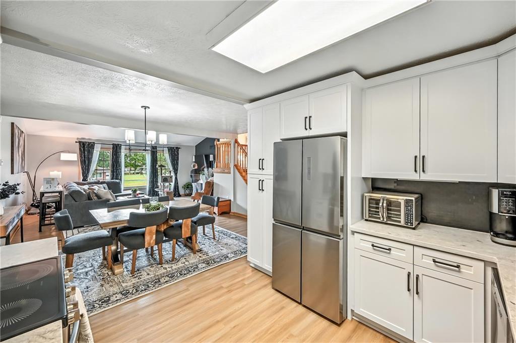 723 Rollinson Road Hermitage, PA 16148 - Photo 11 of 38 a kitchen with stainless steel appliances granite countertop a refrigerator a stove a sink dishwasher and white cabinets with wooden floor