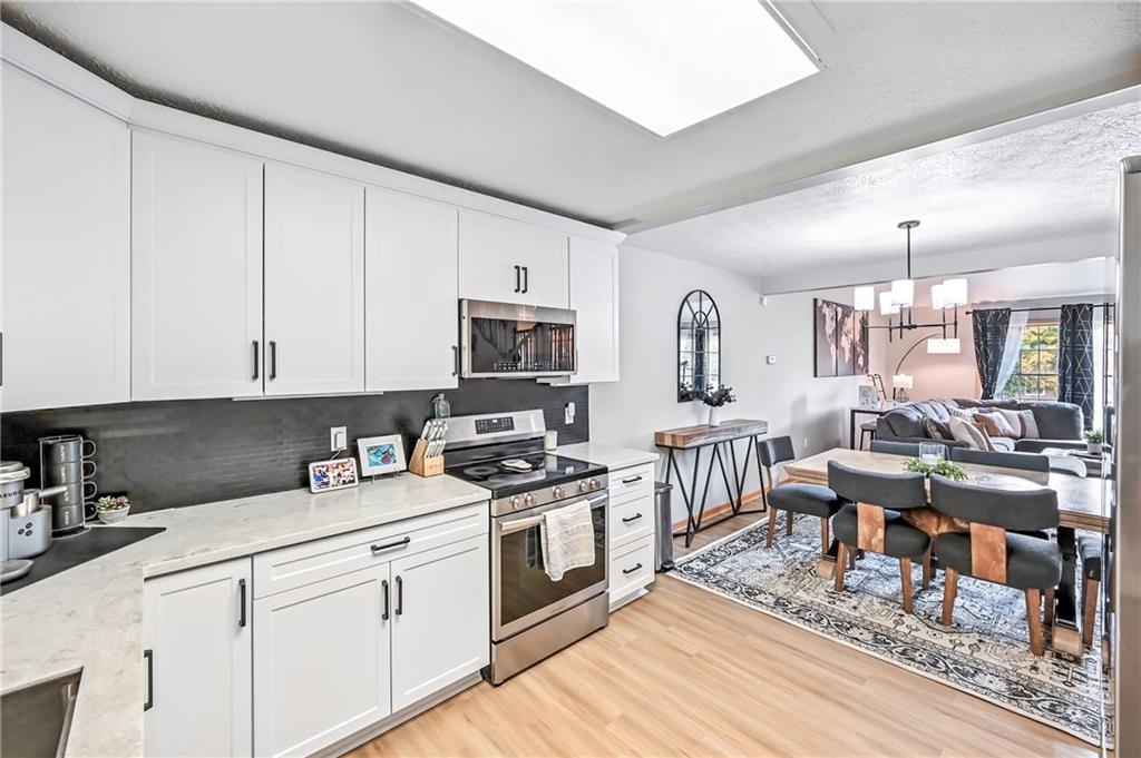 723 Rollinson Road Hermitage, PA 16148 - Photo 12 of 38 a kitchen with stainless steel appliances granite countertop a stove a sink dishwasher and white cabinets with wooden floor