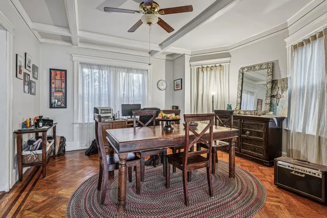 a view of a a dining room with furniture window and wooden floor
