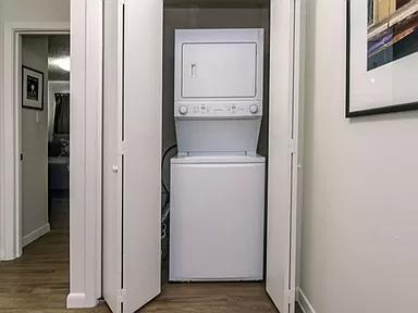 1915 Fairlawn Lane, Unit 2 Austin, TX 78704 - Photo 7 of 12 Laundry area with stacked washer and dryer and dark wood-style flooring