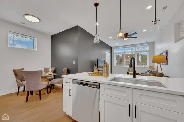 a kitchen with a dining table chairs sink and white cabinets