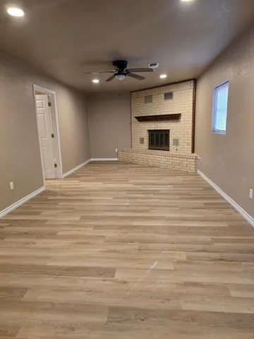 a big room with wooden floor and a fireplace