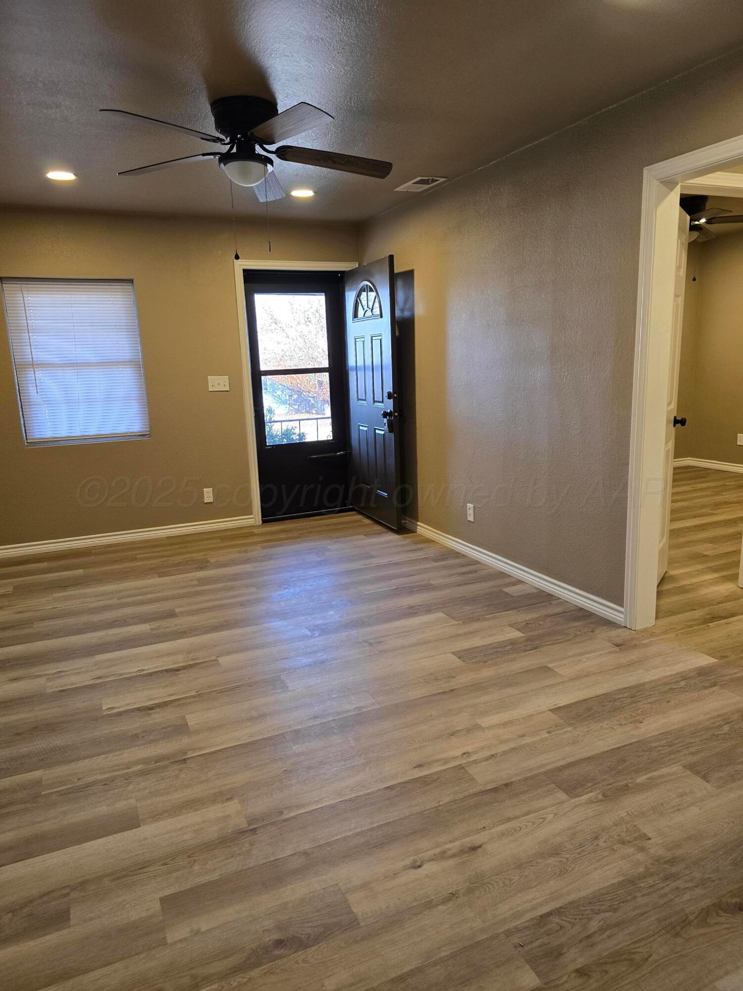 129 Pecan Street Borger, TX 79007 - Photo 18 of 23 a view of an empty room with window and wooden floor