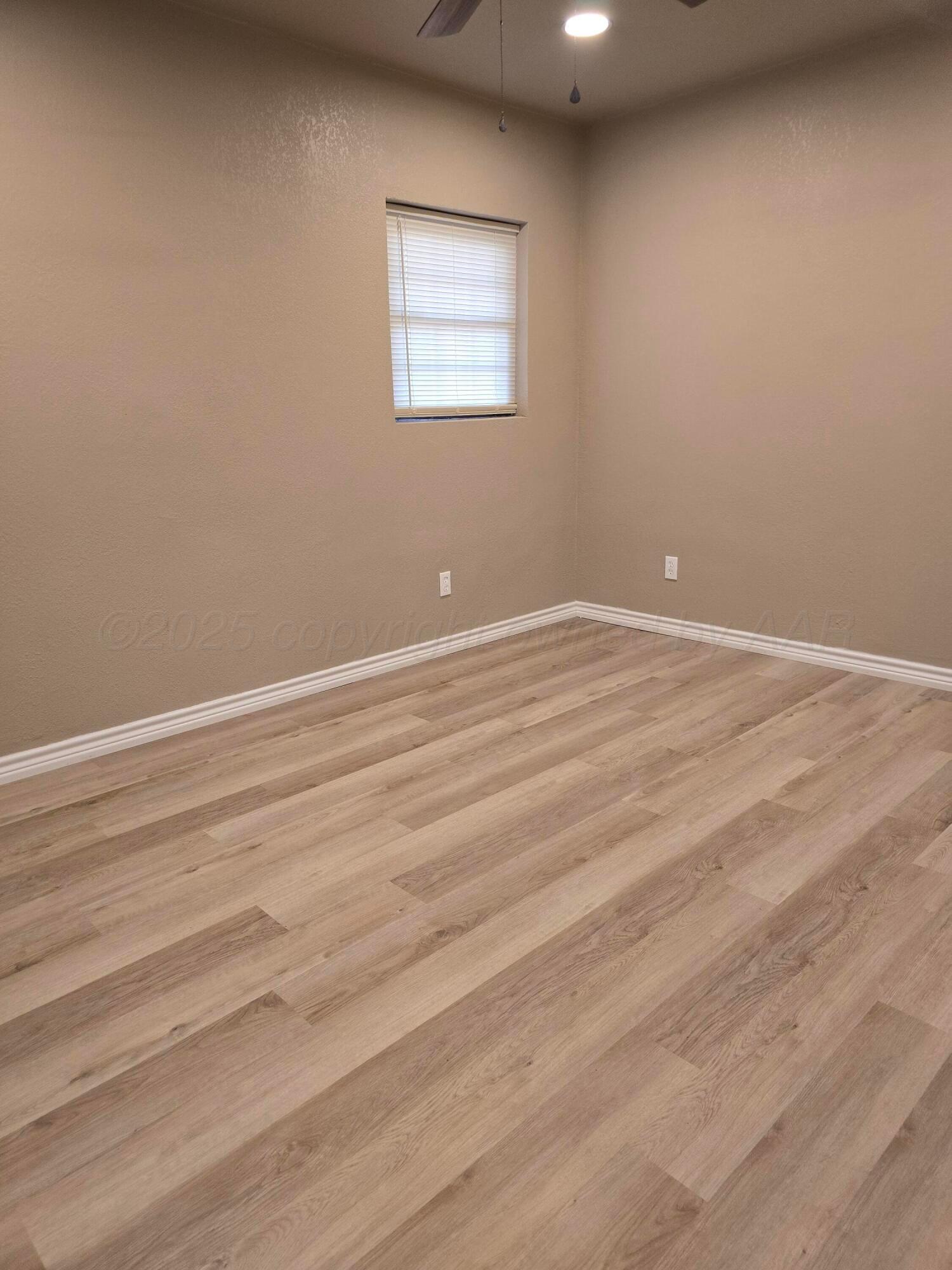 129 Pecan Street Borger, TX 79007 - Photo 21 of 23 a view of an empty room with wooden floor and a window