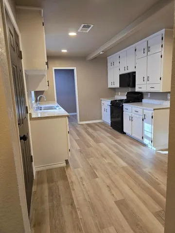 a kitchen with granite countertop a refrigerator stove and sink