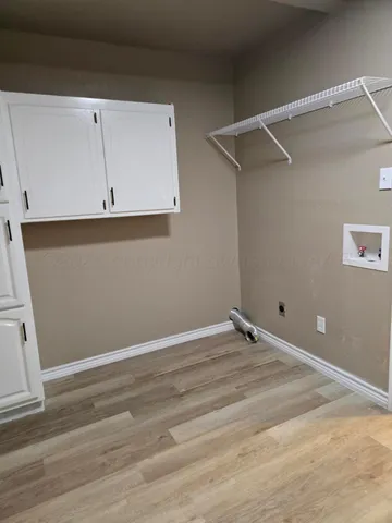 a view of a room with wooden floor and cabinet